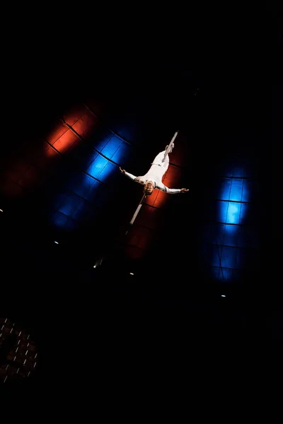 Красивий акробат, що виконує догори ногами на стовпі на арені цирку — стокове фото