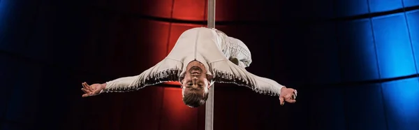 Tiro panorâmico de acrobata forte com as mãos estendidas que executam no pólo metálico — Fotografia de Stock