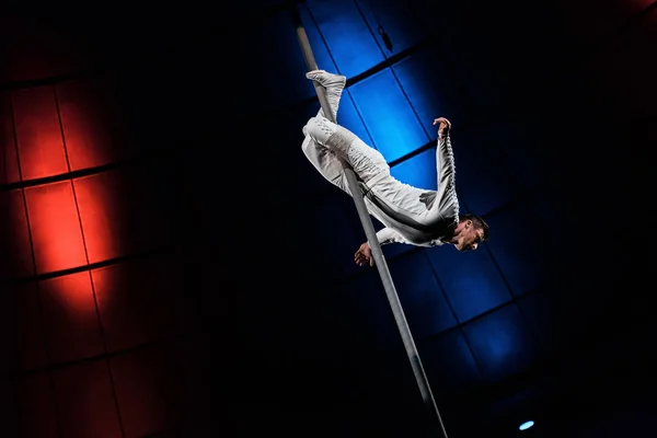 Strong acrobat posing while performing in circus — Stock Photo