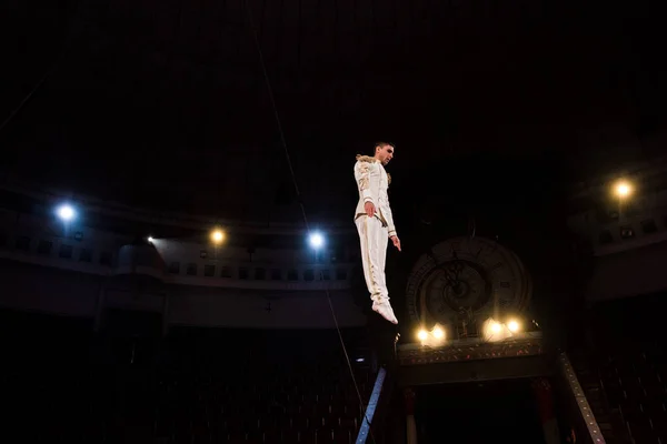 Guapo gimnasta volando en arena de circo - foto de stock