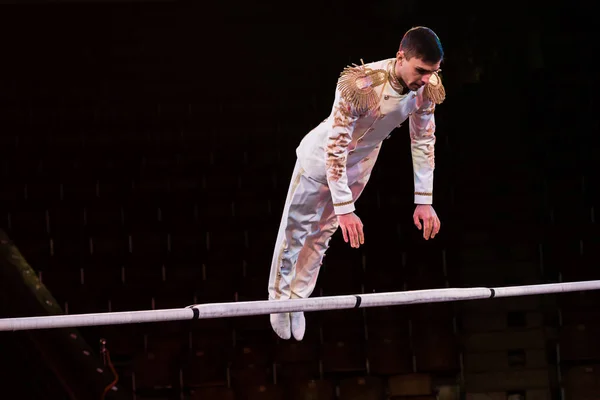 Guapo gimnasta ejercitando cerca de polo en arena de circo - foto de stock