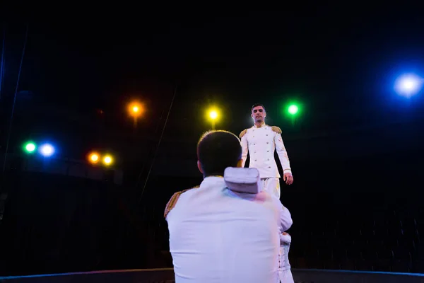 Visão traseira do homem de pé perto acrobata realizando no circo — Fotografia de Stock