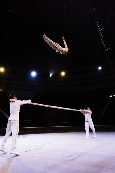 Прыжки воздушного акробата во время выступления у полюса в цирке — стоковое фото