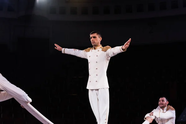 Equilíbrio acrobata ar flexível no pólo perto de ginastas no circo — Fotografia de Stock