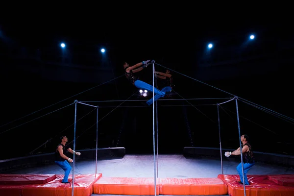 Beaux gymnastes jouant sur des barres horizontales dans le cirque — Photo de stock