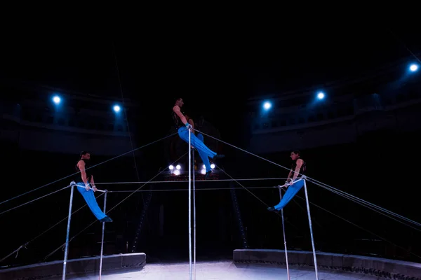 Schöne Akrobaten, die im Zirkus am Stufenbarren auftreten — Stockfoto