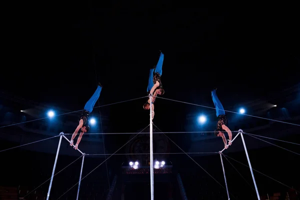 Visão de baixo ângulo de ginastas que se apresentam em bares horizontais no circo — Fotografia de Stock