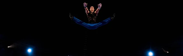 Panoramic shot of gymnast jumping while performing in circus — Stock Photo