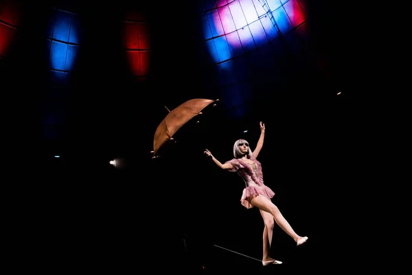 Attrayant acrobate tenant parapluie et debout sur la corde — Photo de stock