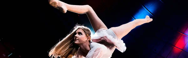 Panoramic shot of flexible girl in costume performing in arena of circus — Stock Photo