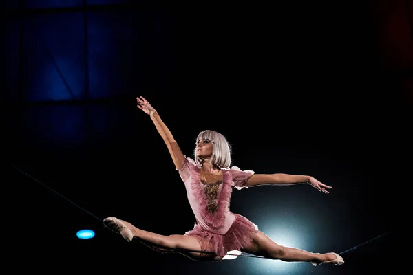 Acrobata aéreo artístico fazendo divisões na corda enquanto se apresenta no circo — Fotografia de Stock