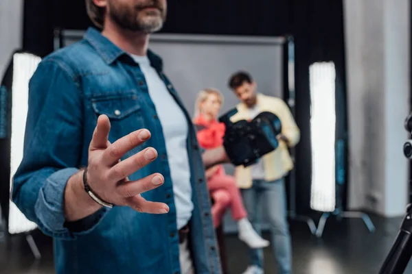 Vista recortada del director de arte gesticulando mientras sostiene la cámara digital - foto de stock