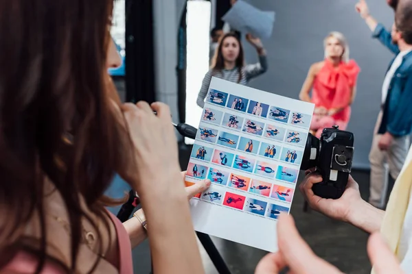 Cropped view of art director and photographer looking at photo collage — Stock Photo