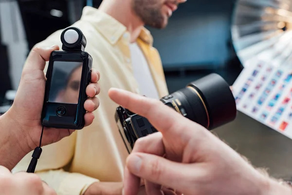 Cropped view of art director pointing with finger at light meter — Stock Photo