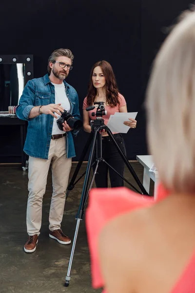 Selective focus of photographer and art director looking at model — Stock Photo
