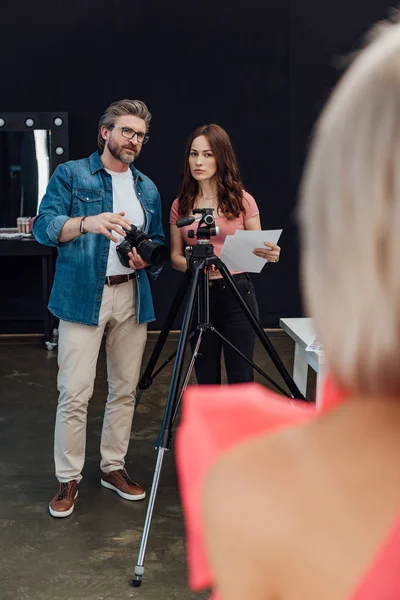 Enfoque selectivo del fotógrafo y director de arte mirando a la modelo - foto de stock