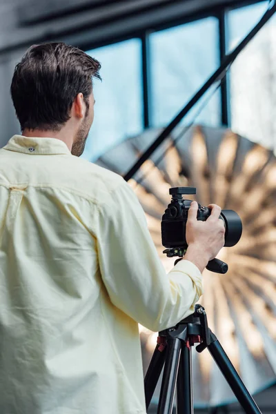 Vista posteriore del fotografo che tocca la fotocamera digitale su treppiede — Foto stock