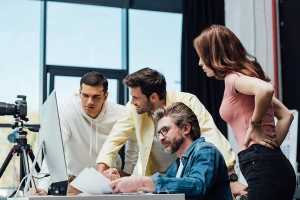 Fröhlicher bärtiger Mann mit Brille und Frau schaut Mitarbeiter in der Nähe des Art Directors an — Stockfoto