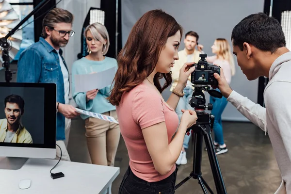 Orientation sélective du directeur artistique travaillant dans un studio photo avec des assistants et des collègues — Photo de stock