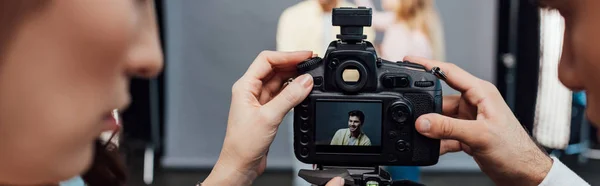 Tiro panorâmico de câmera digital com foto de modelo bonito perto de diretor de arte e fotógrafo — Fotografia de Stock