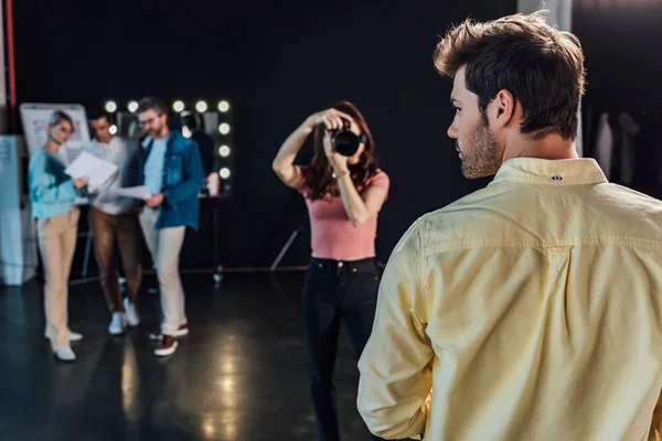 Selective focus of photographer taking photo of bearded man near art director and coworkers — Stock Photo