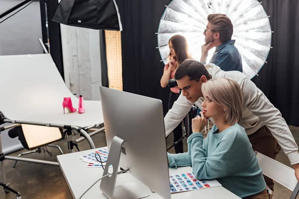 Foyer sélectif des collègues regardant le moniteur d'ordinateur dans le studio de photo — Photo de stock