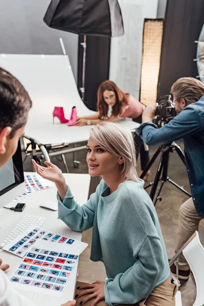 Attrayant directeur artistique gestuelle et regarder assistant — Photo de stock