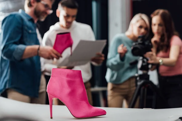 Selektiver Fokus rosa Schuh nahe Team im Fotostudio — Stockfoto