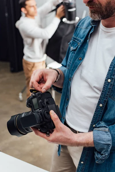 Обрезанный вид бородатого фотографа с цифровой камерой — стоковое фото