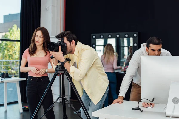 Fotógrafo tomando fotos cerca de director de arte y asistentes - foto de stock