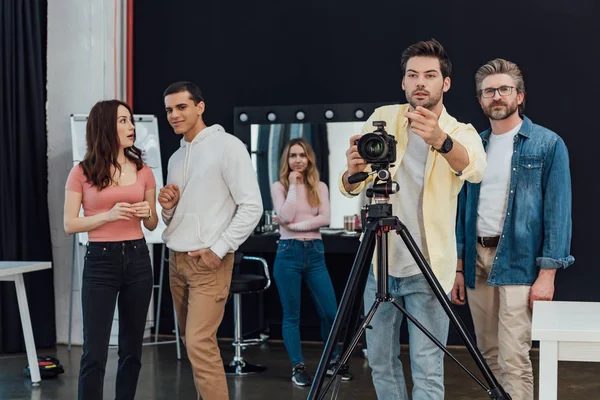 Fotografo gesticolare vicino art director durante il servizio fotografico — Foto stock