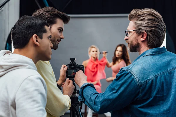 Selective focus of art director standing with photographer and assistant — Stock Photo