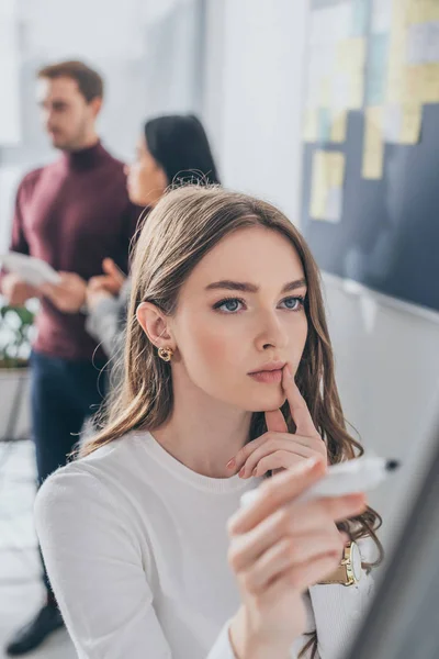 Selective focus of attractive scrum master touching lips near coworkers — Stock Photo