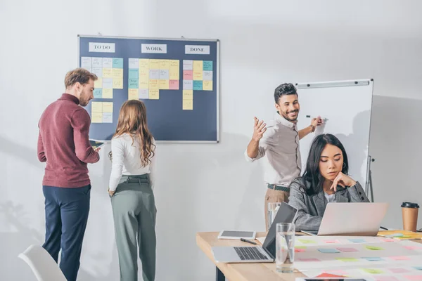 Mestizo hombre de raza con extendido manos cerca asiático empresario y scrum maestros - foto de stock