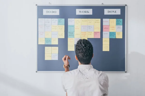 Back view of scrum master standing near board with sticky notes — Stock Photo