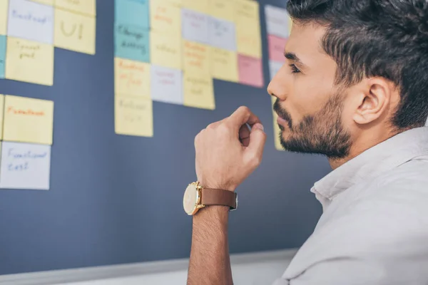 Selective focus of bearded mixed race scrum master looking at board — Stock Photo