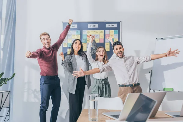 Happy multicultural businesswoman and businessman celebrating in office — Stock Photo