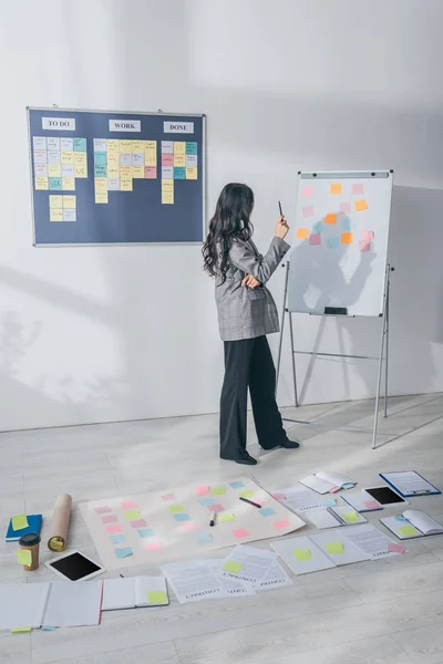 Scrum master standing in modern office near sticky notes on floor — Stock Photo