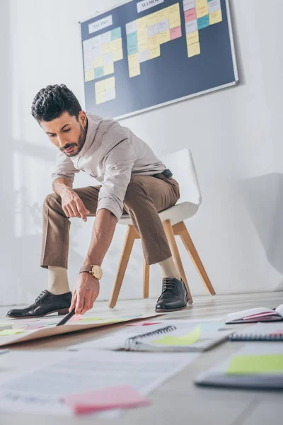 Low angle view of bi-racial scrum master holding marker pen near sticky notes — Stock Photo