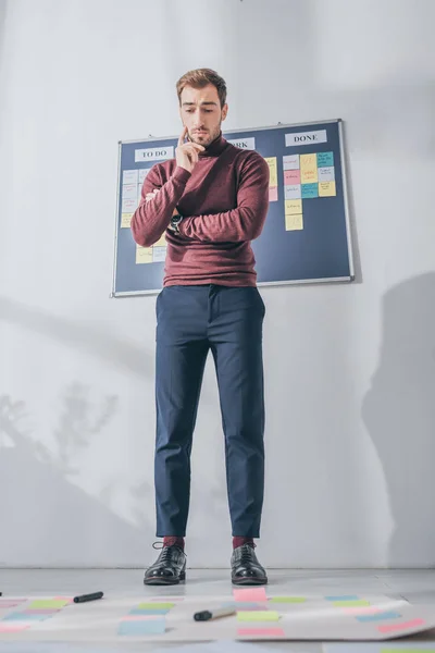 Selective focus of pensive businessman looking at sticky notes on floor — Stock Photo