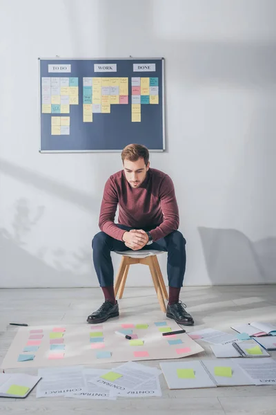Handsome scrum master sitting with clenched hands near sticky notes — Stock Photo