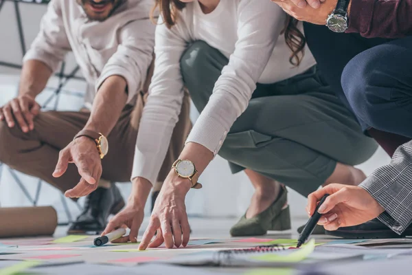 Vista recortada de los maestros scrum apuntando con los dedos al suelo con notas adhesivas - foto de stock