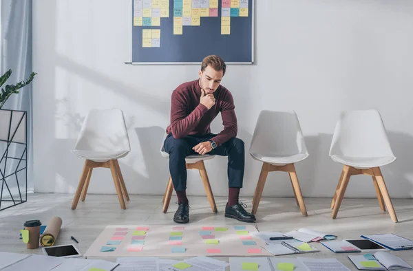 Pensive businessman sitting on chair near sticky notes — Stock Photo