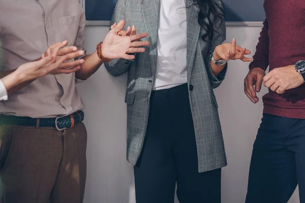 Cropped view of coworkers gesturing and standing in office — Stock Photo