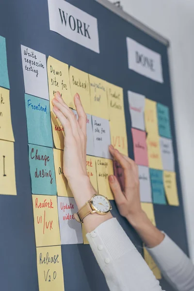 Vista cortada de scrum mestre tocando notas pegajosas com letras no escritório — Fotografia de Stock