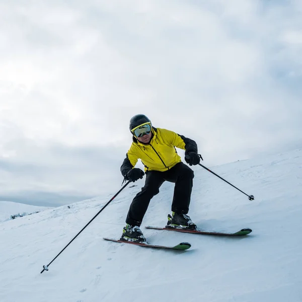 Sportsman holding ski sticks while skiing on white slope — Stock Photo