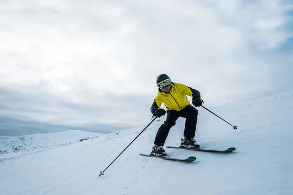 Desportista segurando paus de esqui enquanto esquia na neve branca — Fotografia de Stock