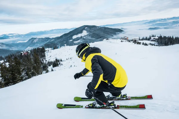 Sportsman in helmet skiing in mountains — Stock Photo