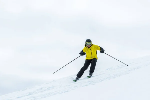 Skieur tenant des bâtons de ski et sportif en hiver — Photo de stock