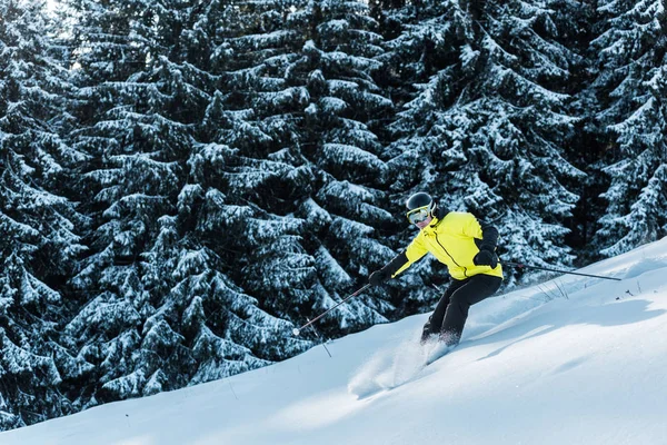 Esquiador em óculos esquiar na neve perto de árvores — Fotografia de Stock